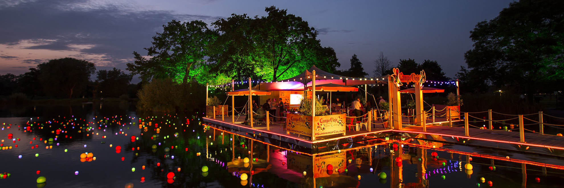 Floating bar on a lake with mulitcolour lights on the lake