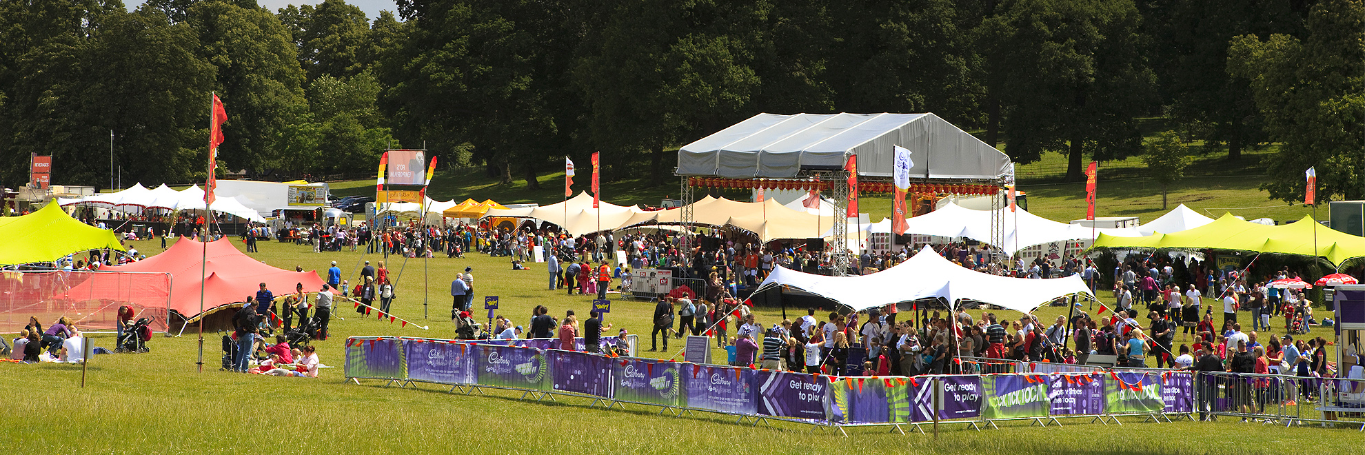 view of field with multiple multi coloured stretch tents roadshow