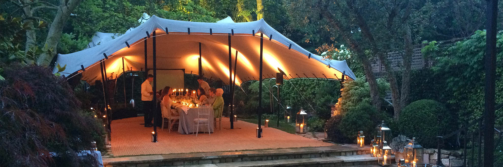 Beige stretch tent with matting in garden