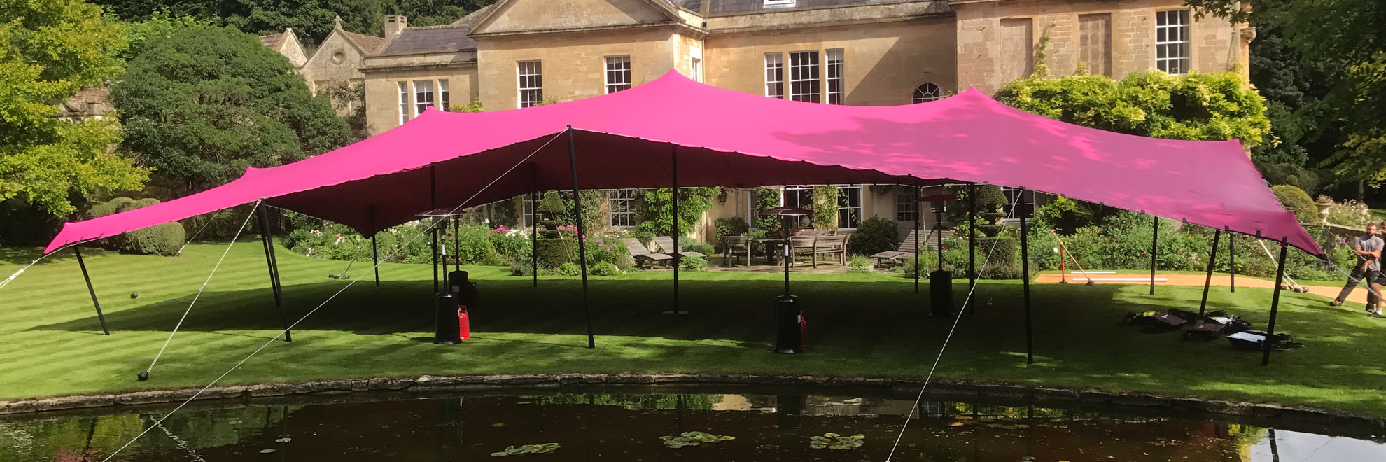 Pink stretch tent inf ront of costwold stone house