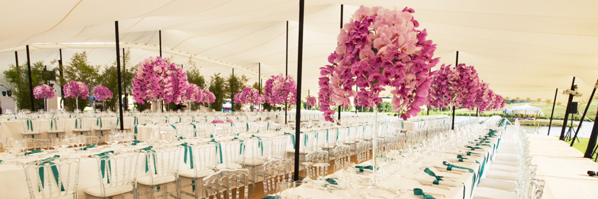 White stretch tent long tables, bright pink flowers