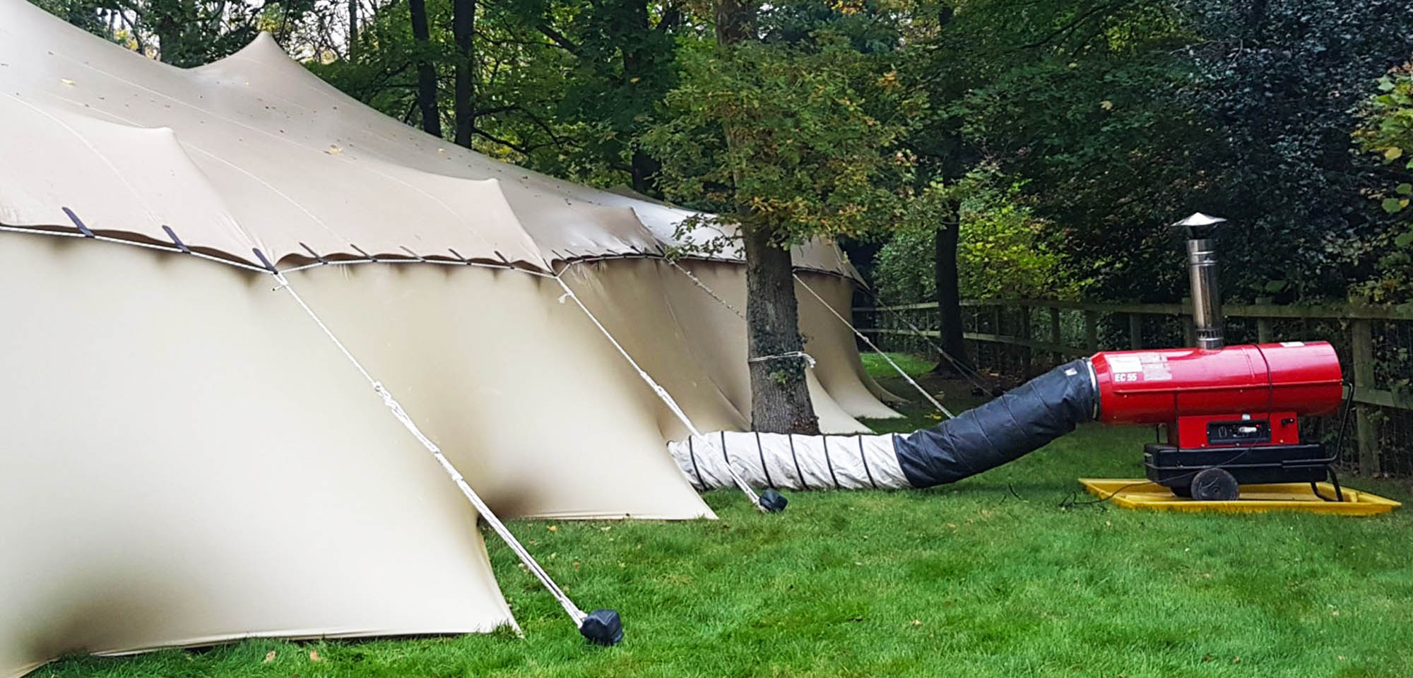 red blow heater going into a beige stretch tent with walling