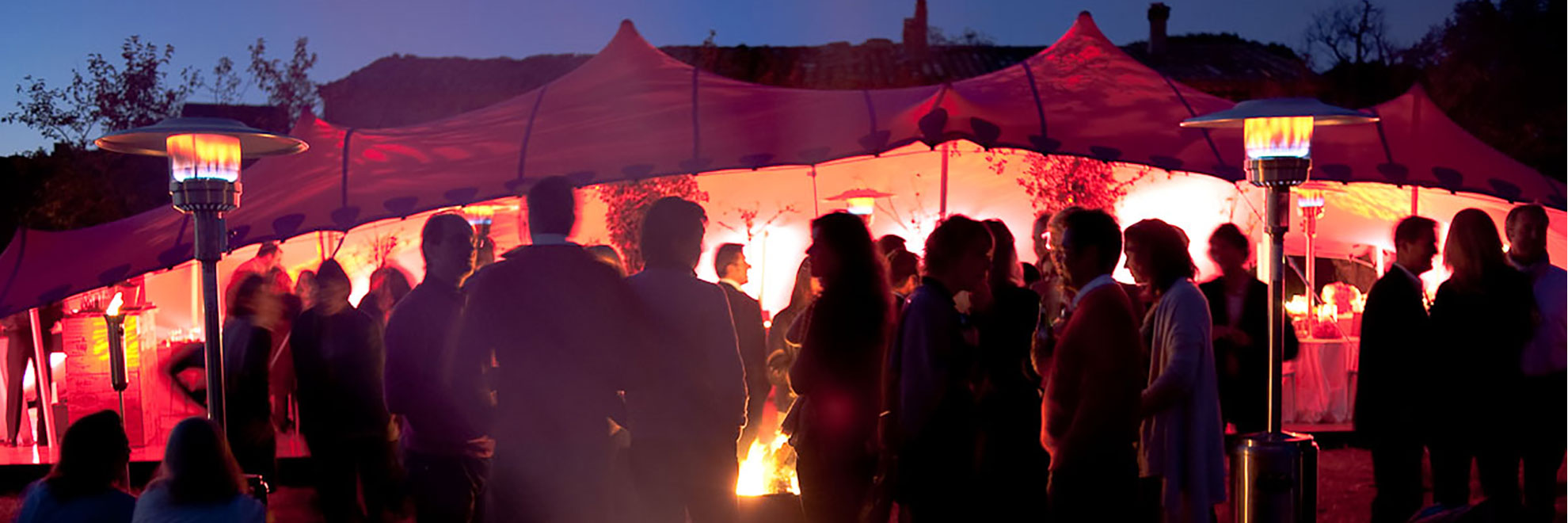 pink stretch tent at dusk lit up with guests