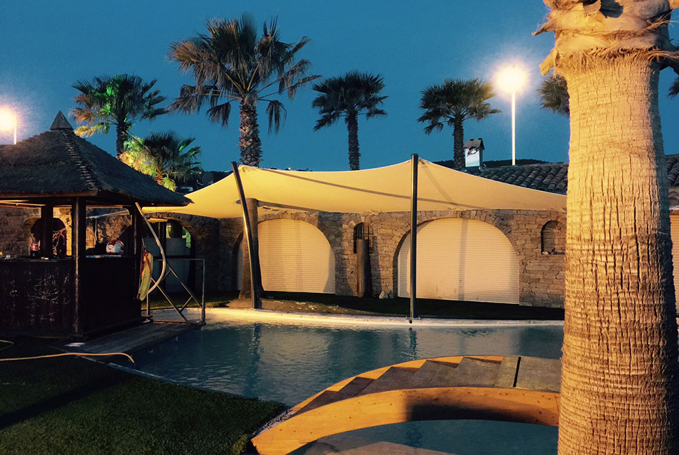 White stretch tent custom fit by a pool